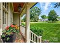 View from covered porch showing landscaped front yard and neighborhood at 2025 Sagamore Rd, Charlotte, NC 28209