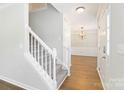 Bright foyer with a stairway, hardwood floors and chandelier-style lighting leading into the living space at 204 Pebble Creek Xing, Fort Mill, SC 29715