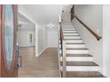 Bright foyer showcasing hardwood floors, a staircase with wood railing, and an inviting entrance to the living area at 219 Proctor Dr, Salisbury, NC 28147
