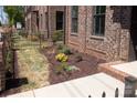 Brick townhome featuring a meticulously landscaped yard with healthy green plantings at 226 Gilead Rd, Huntersville, NC 28078