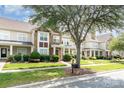 View of townhomes showcasing well-kept lawns, mature trees, and sidewalk at 2324 Bonterra Blvd, Indian Trail, NC 28079