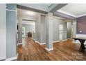 Open entryway with hardwood floors, elegant columns, and neutral paint, leading into the home at 2426 Tory Oak Pl, Matthews, NC 28105