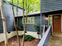 Inviting entryway with wood siding and a warm brown door, nestled among trees at 2800 Patio Ln, Gastonia, NC 28056