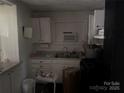 A simple kitchen with white cabinets and basic appliances needs work at 2925 Titman Rd, Gastonia, NC 28054
