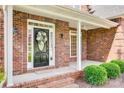 Charming brick front porch with a decorative wreath on the front door and manicured shrubbery at 3741 Tea Olive Rd, Gastonia, NC 28056