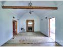 Spacious living room with exposed wood beam, fireplace, and natural light creates a warm atmosphere at 5604 Nc 152 E Hwy, Rockwell, NC 28138