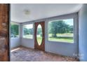 Bright sun room with multiple windows and an oval front door providing lots of natural light at 5604 Nc 152 E Hwy, Rockwell, NC 28138