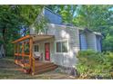 Charming two-story home with a covered wooden porch surrounded by lush trees at 5995 Tall Tree Ln, Harrisburg, NC 28075