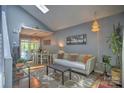 Open living room with hardwood floors, a skylight, modern decor and dining area at 5995 Tall Tree Ln, Harrisburg, NC 28075