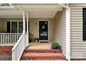 Cozy front porch with brick stairs, white railing, and a 'Welcome' sign on the black screen door at 605 Beavers Cove Nw Ln # 15, Concord, NC 28027