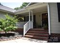 Inviting front porch with brick steps, white railing, and a charming, covered entrance at 605 Beavers Cove Nw Ln # 15, Concord, NC 28027
