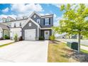 Stylish two-story gray townhome featuring a one-car garage, a well-manicured lawn, and attractive landscaping at 711 Bellmouth Rd, Clover, SC 29710