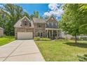 Charming two-story brick home featuring a manicured lawn and a two-car garage at 8336 Early Bird Way, Mint Hill, NC 28227