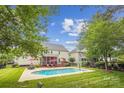 Backyard featuring a private pool with deck furniture and a well-maintained lawn at 8612 Tintinhull Ln, Waxhaw, NC 28173