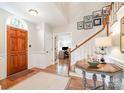 Welcoming foyer features a staircase, elegant table, and arched doorway to the office at 8700 Thornbury Ln, Huntersville, NC 28078