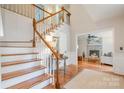 Inviting foyer with wood floors, staircase, and a glimpse of the living room fireplace at 8700 Thornbury Ln, Huntersville, NC 28078