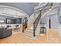 A view of the foyer featuring hardwood floors and wrought iron staircase, transitioning into the open living area at 9021 Unbridle Ln, Waxhaw, NC 28173