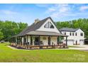 Inviting exterior showcasing a home with a wraparound porch, black trim, and manicured lawn at 930 Hawley Rd, McConnells, SC 29726