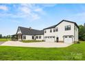 Spacious home with a three-car garage and a large driveway, set against a backdrop of clear blue skies at 930 Hawley Rd, McConnells, SC 29726