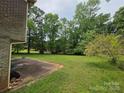 Spacious backyard with lush green grass, mature trees and a patio, perfect for outdoor activities at 1105 Stanton Dr, Shelby, NC 28150