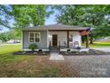 Charming home featuring a welcoming front porch, fresh landscaping, and a mix of modern and traditional design elements at 118 Globe St, Mount Holly, NC 28120