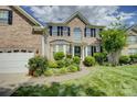 Beautiful brick home with manicured lawn and walkway leading to the front door at 12125 Mountainside Ln, Charlotte, NC 28278