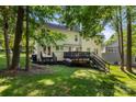 Spacious backyard with a wooden deck, stairs, and mature trees, perfect for entertaining at 12602 Angel Oak Dr, Huntersville, NC 28078