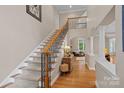 Bright foyer featuring staircase with wooden railing and iron spindles, and hardwood floors at 166 Pinnacle Shores Dr, Mooresville, NC 28117