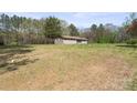 Wide shot of home on large lot showcasing its setting within mature trees at 174 Maske Rd, Mount Gilead, NC 27306