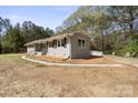 Side view of the renovated home featuring a light grey brick facade and new walkway at 174 Maske Rd, Mount Gilead, NC 27306