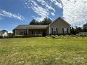 Charming one-story home featuring meticulously landscaped yard and a welcoming covered front porch at 190 Watering Trough Rd, Statesville, NC 28677