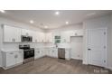 Well-lit modern kitchen with stainless steel appliances, white cabinets and wood-look flooring at 1941 32Nd Ne St, Hickory, NC 28601