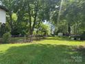 Wide shot of green backyard, lined with trees and a small storage building at 204 N Gaston St, Kings Mountain, NC 28086