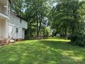 Large backyard with a storage building in the back, green lawn and large trees at 204 N Gaston St, Kings Mountain, NC 28086