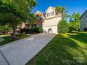 A view of the home showing the driveway, two car garage, and neutral siding at 2111 Elendil Ln, Charlotte, NC 28269
