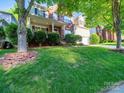 Attractive two-story home featuring a brick facade, inviting front porch, and a large grassy yard at 2111 Elendil Ln, Charlotte, NC 28269