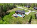 Aerial view of a brick home with a pool, a covered patio, and a well-manicured lawn at 2458 Genelia Dr, Claremont, NC 28610