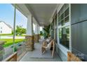 Relaxing front porch featuring stone-clad pillars, comfortable wicker seating, and views of the landscaped yard at 2714 Woodlands Creek Dr, Monroe, NC 28110