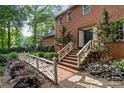 Front door with brick steps and a charming white fence surrounded by lush landscaping at 3209 Sedgefield Rd, Statesville, NC 28625