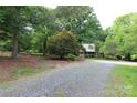 Beautiful home with mature trees and landscaping in a wooded lot with a circular gravel driveway at 344 Lucas Rd, Star, NC 27356