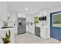 Modern kitchen featuring white cabinets, stainless steel appliances, and a bright window over the sink at 4108 Mellon Rd, Matthews, NC 28104