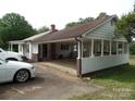 Back of home featuring a long carport, a sunroom, and a white exterior at 5004 King Wilkinson Rd, Denver, NC 28037