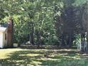 View of the private backyard, backing to a wooded area, and partially enclosed with fencing at 555 Ridge Ave, Mooresville, NC 28115