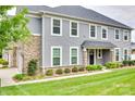 Well-maintained two-story home featuring stone accents, vinyl siding, and a lush green lawn with manicured landscaping at 5836 Clan Maclaine Dr, Charlotte, NC 28278