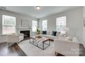 Bright living room featuring a cozy fireplace, neutral furniture, and plenty of natural light from large windows at 5836 Clan Maclaine Dr, Charlotte, NC 28278