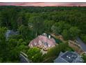 Expansive aerial view of wooded property showcasing large home with water feature at 5915 Vidal Ln, Charlotte, NC 28226
