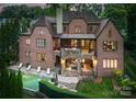 A beautiful backyard showcasing the pool, patio, and stone arches of this brick home at 5915 Vidal Ln, Charlotte, NC 28226