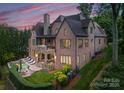 Stately brick home with stone accents, balcony, and a pool and patio area at 5915 Vidal Ln, Charlotte, NC 28226
