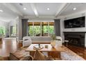 Bright living room features a fireplace, dark wood floors, and views through the large windows at 5915 Vidal Ln, Charlotte, NC 28226