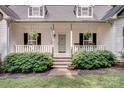 Inviting front porch with decorative plants and cozy seating, leading to the main entrance at 592 Woodcrest Dr, Gastonia, NC 28056